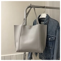 Detail of light gray faux leather tote bag with gold snap button and durable stitching - Gray