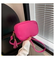 Detail of rose pink crossbody camera bag with litchi grain leather and tassel charm - Rose Red