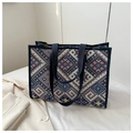 Detailaufnahme einer Canvas-Tote-Bag mit Ethno-Muster neben einem cremefarbenen Blazer - Blau