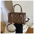 Detail of the brown quilted handbag with V-shaped stitching and metallic silver hardware - Brown