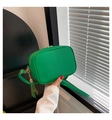Detail of green lychee-textured crossbody bag with golden zipper and leather tassel charm - Green