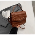 Detail van bruine gewatteerde handtas met gouden hardware en elegant handvat - Bruin