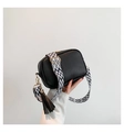 Black pebbled leather camera bag with a wide black and white geometric pattern strap - Black
