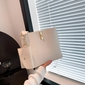 Minimalistische beige Beuteltasche mit goldener Schließe und passendem Beutelanhänger - Gebrochenes Weiß