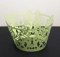Close-up of laser-cut reindeer and snowflake hollow patterns on green cupcake wrappers - Fruit Green