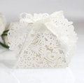 Detail of white laser-cut wedding favor box with intricate heart and butterfly patterns - Ivory