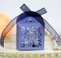 Detailed close-up of purple laser-cut wedding favor box with ribbon and floral patterns - Sapphire Blue