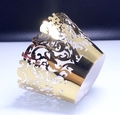 Macro shot of laser-cut lace cupcake wrappers in metallic gold with vine patterns - Reflective Gold