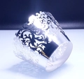 Macro shot of silver laser-cut cupcake wrappers with mirror finish and lace vine patterns - Reflective Silver