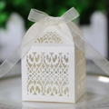 Macro view of white laser-cut gift box with intricate heart patterns and ribbon bow - Ivory
