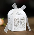 Elegante weiße lasergeschnittene Pralinenschachtel mit Schleife auf dunklem Holzboden - Weiß