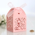 Close-up of pink laser-cut flower wedding favor box with ribbon bow on pearlescent paper - Pink