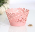 Pink laser-cut lace cupcake wrapper with intricate floral hollow patterns on white background - Pink