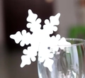 White snowflake laser-cut place cards for wine glass decoration in Christmas party setting - White