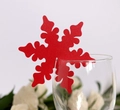 Close-up of laser-cut red snowflake placeholder card on a glass rim for parties - Pearlescent Red