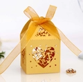 Detailed view of a golden hollow LOVE heart wedding candy box with a silk ribbon bow - Gold