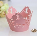 Intricate laser-cut pink cupcake wrapper featuring a romantic kissing couple design - Pink
