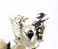 Detail of silver laser-cut cupcake wrappers with Halloween witch and castle patterns - Silver