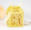 Detail of yellow laser-cut gift box with intricate vine patterns and organza ribbon - Gold