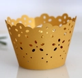 Macro detail of golden laser-cut cupcake wrapper with elegant floral hollow patterns - Gold