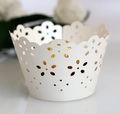 Macro detail of laser-cut floral cupcake wrapper in light blue with elegant hollow pattern - Ivory