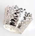 Macro shot of silver laser-cut cupcake wrappers with elegant hollowed leaf pattern details - Reflective Silver