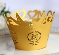 Close-up of laser-cut gold cupcake wrapper featuring bird and heart hollow designs - Gold
