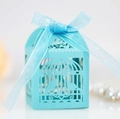 Close-up of laser-cut birdcage favor box in sky blue with ribbon and hollow heart detail - Tiffany Blue