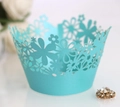 Makro-Detail von himmelblauen lasergeschnittenen Cupcake-Förmchen mit Blumenmustern - Tiffany-Blau