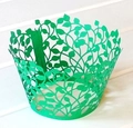 Detail of green laser-cut cupcake wrapper featuring a delicate leaf and vine pattern - Dark Green