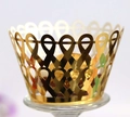 Détail macro d'un emballage de cupcake doré découpé au laser avec motifs de nœuds - Or Réfléchissant