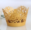 Close-up of golden laser-cut cupcake wrapper with intricate geometric lace pattern - Gold Yellow