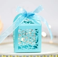 Close-up of light blue laser-cut gift box featuring intricate swirl patterns and ribbon bow - Tiffany Blue