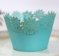 Makro-Detail der lasergeschnittenen Sonnenblume auf cyanblauen Cupcake-Förmchen für Partys - Tiffany Blau