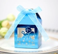 Detail of blue laser-cut angel gift box with stars and a silk ribbon on a plate - Reflective Blue
