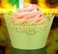 Close-up of light green laser-cut cupcake wrappers with floral daisy pattern and pink frosting - Light Green