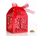 Macro detail of red laser-cut wedding favor box with intricate patterns and silk ribbon - Pearlescent Red