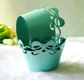 Detail of mint green laser-cut cupcake wrapper with pearl glitter finish and bow pattern - Tiffany Blue