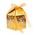 Close-up of golden laser-cut wedding favor box featuring cross hollow design and ribbon - Reflective Gold