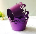 Close-up of purple laser-cut cupcake wrappers with elegant hollow bow-knot design - Dark Purple