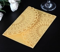 Macro detail of laser-cut gold pearlescent paper wedding invitation with floral patterns - Gold