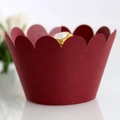 Macro view of burgundy paper cupcake wrappers with elegant scalloped edges for desserts - Dark Red