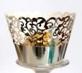 Macro shot of silver laser-cut cupcake wrapper with intricate vine patterns and mirror finish - Reflective Silver