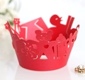 Macro view of red laser-cut cupcake wrapper featuring cartoon bear and bottle patterns - Pearlescent Red