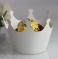 Macro shot of a white paper crown cupcake liner holding a golden wrapped chocolate - Starry White