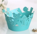 Close-up of laser-cut baby shower cupcake wrapper with bear and bottle patterns - Tiffany Blue