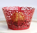 Detail of laser-cut wedding cupcake wrapper with intricate vine and leaf patterns - Pearlescent Red