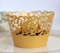 Close-up of laser-cut gold cupcake wrapper with intricate vine patterns on a white plate - 5*5*8CM / Gold Yellow