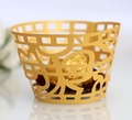 Close-up of golden laser-cut cupcake wrappers with Happy lettering for festive decor - Gold Yellow