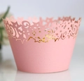 Nahaufnahme von rosa Cupcake-Förmchen mit lasergeschnittenen Sternen und Schnörkeln - Rosa